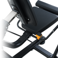 Close-up of a Insight Fitness Leg Curl/Extension - BE8025 seat with an orange component on a white background